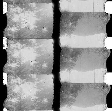 A still from Four Mountains of an unslit 8mm film with 4 black and white landscape images